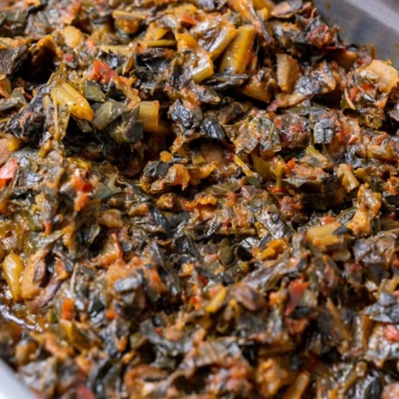 Close-up of a large serving of Nigerian Efo Riro, a stewed leafy green vegetable dish.